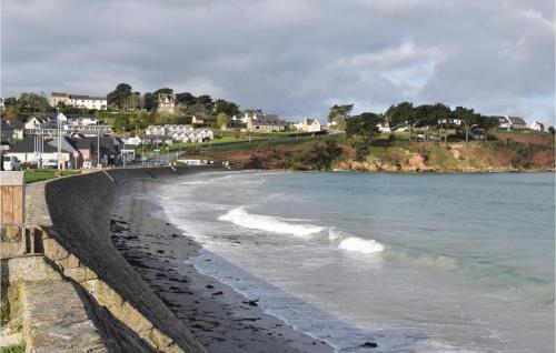 a beach with the ocean and houses in the background at Stunning Apartment In Trevou Treguignec in Trévou-Tréguignec