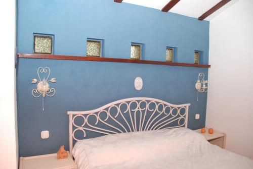 - une chambre avec un mur bleu et un lit dans l'établissement Vila Poiana, à Snagov