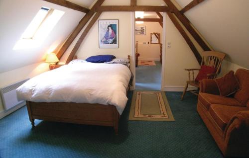 a bedroom with a bed and a chair in a attic at Amazing Home In Embry With Wifi in Embry