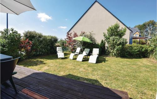 - un groupe de chaises et un parasol sur une cour dans l'établissement Nice Home In Port-En-Bessin-Huppain, à Huppain