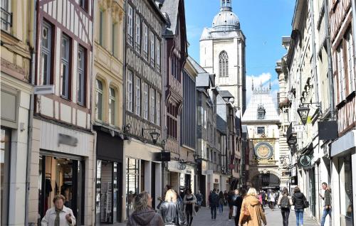 un groupe de personnes marchant dans une rue avec une tour d'horloge dans l'établissement Gorgeous Apartment In Le Mesnil-Esnard, à Le Mesnil-Esnard