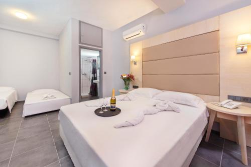 a hotel room with a bed with a bottle of champagne at Villa Mare by Delfinia Resort in Kolimbia