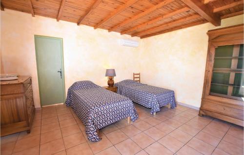a room with two beds and a table with a lamp at Beautiful Home In Cairanne With 5 Bedrooms, Wifi And Private Swimming Pool in Cairanne
