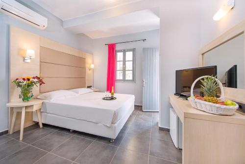 a hotel room with a bed and a television at Villa Mare by Delfinia Resort in Kolymbia