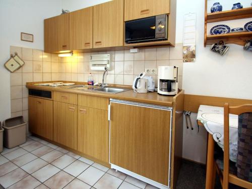 Il comprend une petite cuisine équipée d'un évier et d'un four micro-ondes. dans l'établissement Apartment, Dornumersiel, à Dornumersiel