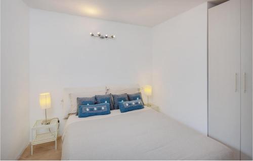 - une chambre blanche avec un grand lit et des oreillers bleus dans l'établissement Beautiful Apartment In Pitelli -sp- With Kitchen, à Muggiano