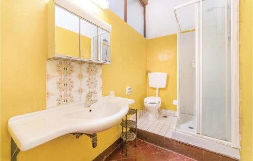 uma casa de banho amarela com um lavatório e um WC em Barbaiano C em Monte San Savino