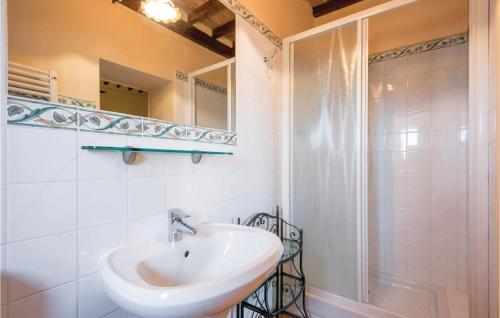 een witte badkamer met een wastafel en een douche bij La Cisterna in Monte San Savino