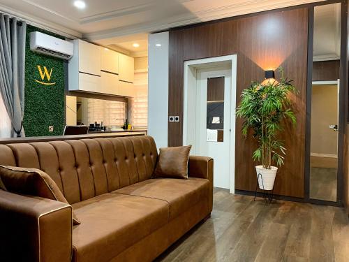 a living room with a couch and a plant at Whytescape Serviced Apartments in Abuja