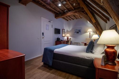 a bedroom with a large bed in a room at Grand Hotel en Résidence De Draak in Bergen op Zoom