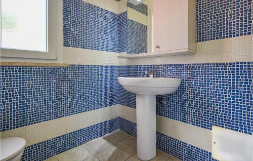 bagno con pareti piastrellate blu e lavandino di Pet Friendly Home In Cavo With House Sea View a Cavo