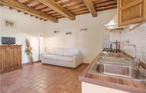uma cozinha com um lavatório e um sofá num quarto em Frantoio em Lamporecchio
