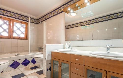 La salle de bains est pourvue de 2 lavabos et de toilettes. dans l'établissement 8 Bedroom Amazing Home In Riudellots, à Riudellots de la Selva