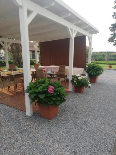 a pavilion with tables and potted plants on a patio at Villa Ceirano in Lagnasco