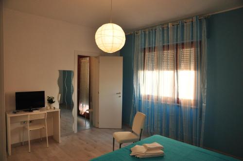 a room with a bed and a desk and a television at Domus Primavera in Scerne
