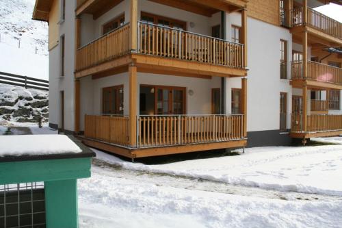 ein Apartmenthaus mit Balkon im Schnee in der Unterkunft Eva Maria 1 by SMR Rauris Apartments - inc Spa and National Summercard - near Gondola in Rauris