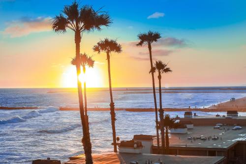 a group of palm trees on the beach at sunset at D313 - Sea Blue in Oceanside