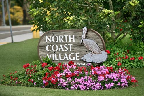 a sign for a north coast village with flowers at D313 - Sea Blue in Oceanside