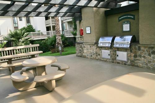 a patio with a grill and a table and benches at D313 - Sea Blue in Oceanside