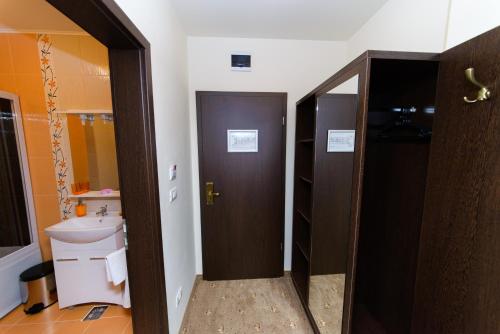 a bathroom with a brown door and a sink at Hotel Miky in Arad