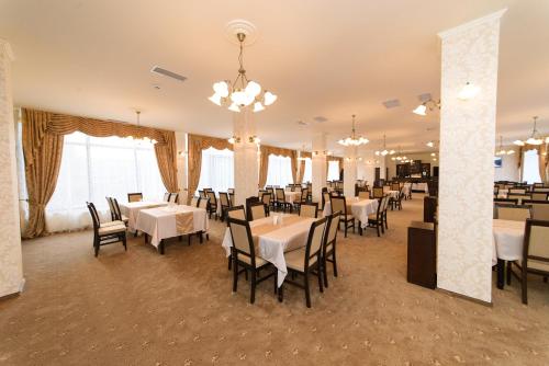 a dining room with white tables and chairs at Hotel Miky in Arad