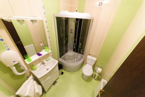 a bathroom with a shower and a toilet and a sink at Hotel Miky in Arad