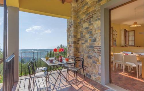 Un patio con una mesa y sillas en un balcón. en 2 Bedroom Nice Home In Camaiore Lu, en Corsanico-Bargecchia