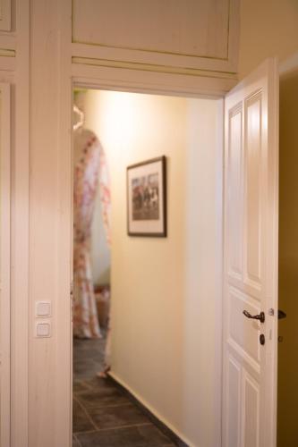 a hallway with a white door and a picture on the wall at The Beach House in Néa Péramos