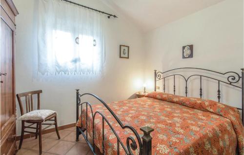 a bedroom with a bed and a chair and a window at Sughereto 2 in Caldana