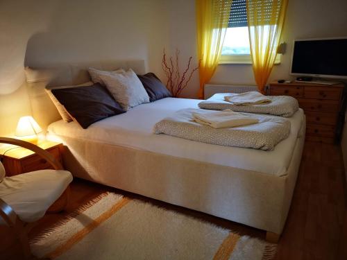 ein Schlafzimmer mit einem Bett mit Handtüchern darauf in der Unterkunft Mészáros apartman in Bük