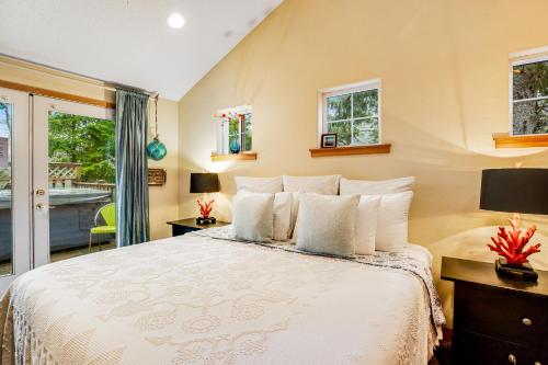 a bedroom with a large bed and a balcony at Jetty Oar Knot in Rockaway Beach