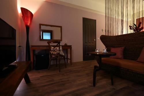 ein Wohnzimmer mit einem Sofa, einem Tisch und einem Spiegel in der Unterkunft 大花紫薇田園民宿-附電梯 in Jian