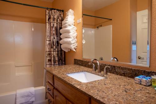 ein Bad mit einem Waschbecken und einem Spiegel in der Unterkunft Little Valley Inn in Mariposa