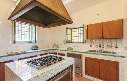 a large kitchen with a stove top oven at Castello Mortellito in Spadafora