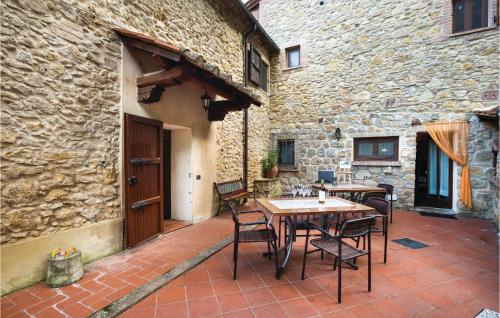 a patio with tables and chairs and a stone building at I Gigli in Ulignano