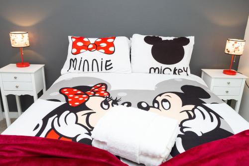 a bedroom with a bed with a mickey mouse bedspread at Gorgeous and New House at Le Reve Resort (214221) in Kissimmee