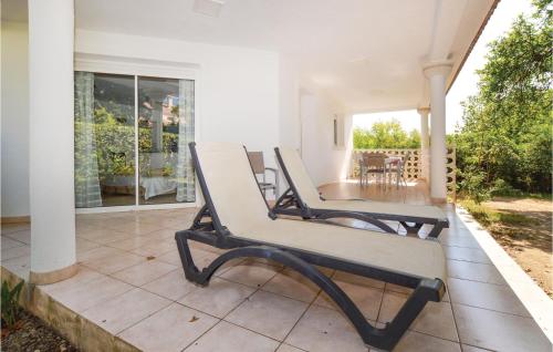 un banc installé sur la terrasse couverte d'une maison dans l'établissement 3 Bedroom Nice Home In Moriani Plage, à Moriani-Plage