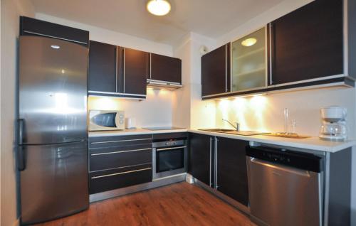 une cuisine avec des armoires noires et des appareils en acier inoxydable dans l'établissement Lovely Apartment In Canet En Roussillon, à Canet