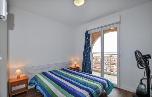 Nice Apartment In Canet En Roussillon With 3 Bedrooms في كانيه ان روسيلون: غرفة نوم بسرير ونافذة كبيرة