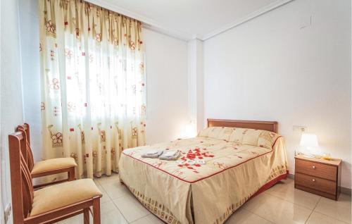 een slaapkamer met een bed, een stoel en een raam bij Beach Front Apartment In Oropesa Del Mar With House A Mountain View in Oropesa del Mar