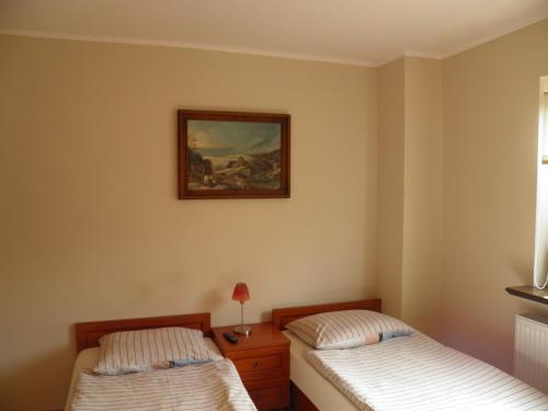 - une chambre avec 2 lits et un tableau mural dans l'établissement Pensjonat Zofia Demska, à Brzeg