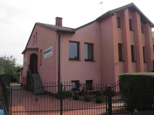 a pink building with a fence in front of it at Pensjonat Zofia Demska in Brzeg