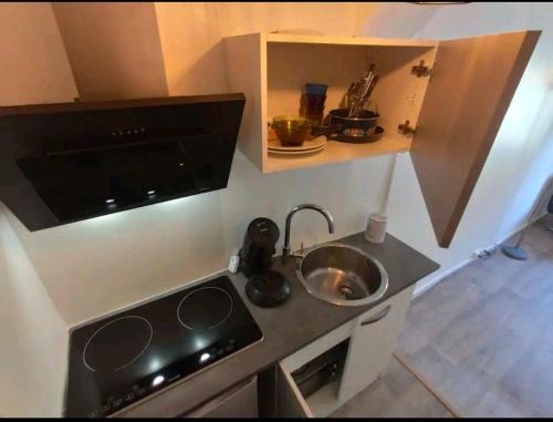 une petite cuisine avec un évier et une cuisinière dans l'établissement Studio hypercentre à 2 pas de la gare appart n°2, à Agen