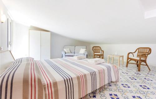 a bedroom with a bed with a striped blanket and chairs at Villa Dellolivo in Sorrento