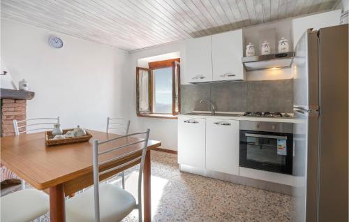 cocina con armarios blancos, mesa y fogones en Casa Gaia, en Culla