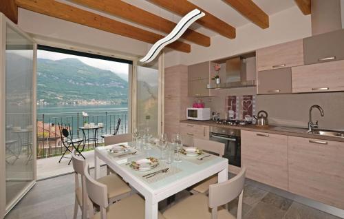 a kitchen with a white table and chairs and a balcony at Pescau House in Lezzeno