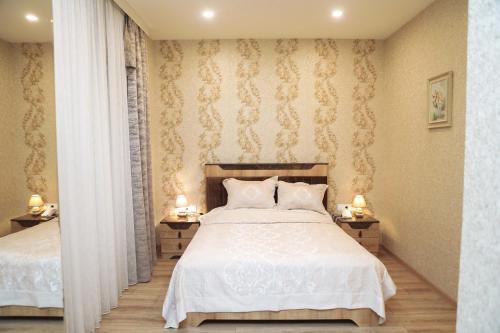 a bedroom with two beds and two lamps on tables at MidCity Hotel in Baku