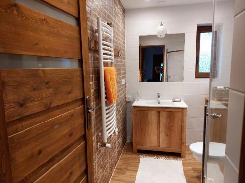 baño con puerta de madera y lavamanos en Appartment, Wieliczka by Cracow, en Wieliczka