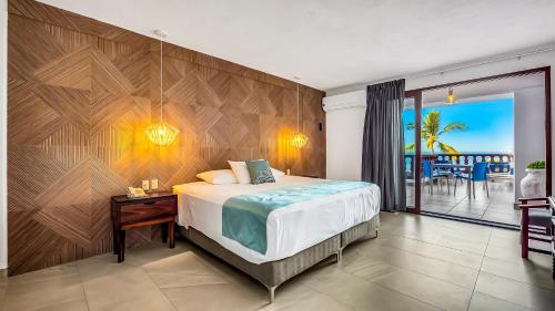 a bedroom with a bed and a view of the ocean at Marboka Hotel & Suites in Puerto Vallarta