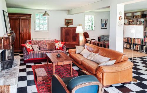 un salon avec des meubles en cuir et un chien assis sur un canapé dans l'établissement 3 Bedroom Nice Home In Clohars-Carnoet, à Keranquernat